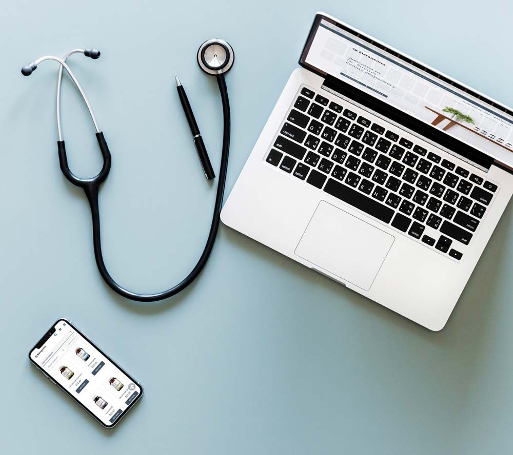  Laptop computer and mobile device open to Metagenics online store with pen and stethoscope