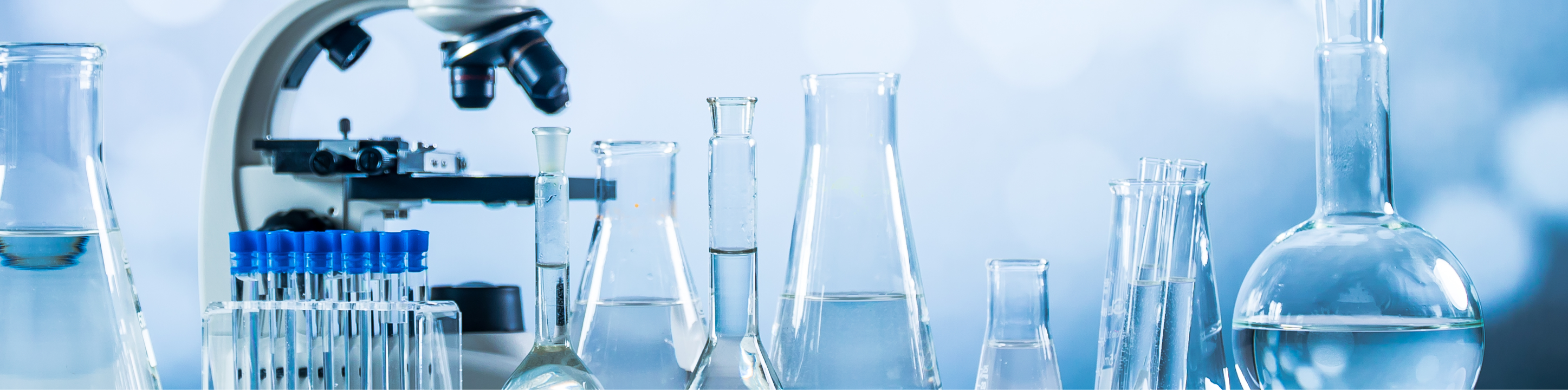 Microscope, test tubes, and beakers in a testing lab